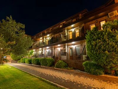 Assos Park Hotel gece otel binası ve bahçe görünümü