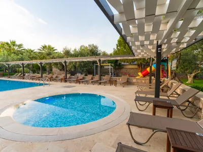Assos Park Hotel havuz başı şezlong ve pergola alanı