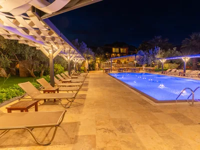 Assos Park Hotel akşam saatlerinde havuz başı şezlonglar